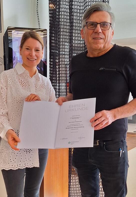 Ehrenurkunde zum Geschäftsjubiläum: HBE-Referentin Julia Killer und Inhaber Robert Wengenmeier.