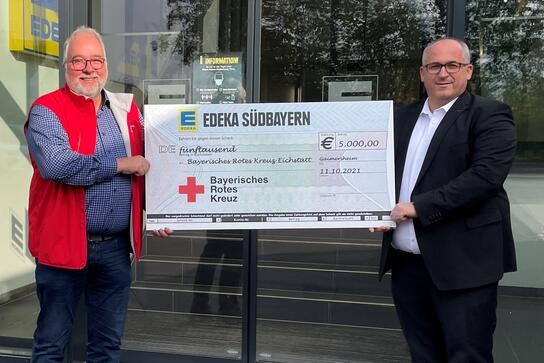 Edeka Südbayern-Vorstand Claus Hollinger (r.) überreicht Michael Gorum (l.), Kreisgeschäftsführer des BRK Eichstätt, den Spendenscheck.