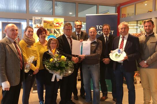 Auszeichnung (v.l.n.r.): Bürgermeister Josef Wallner, Denise Irmer, Susanne Schindler, Iris Haslbeck, HBE-Bezirksgeschäftsführer Josef Kellermann, Josef Haslbeck, dahinter Bernhard Himmelstoß und Alois Eder von Edeka Südbayern, Landrat Josef Laumer, Wirtschaftsförderer Martin Köck. 